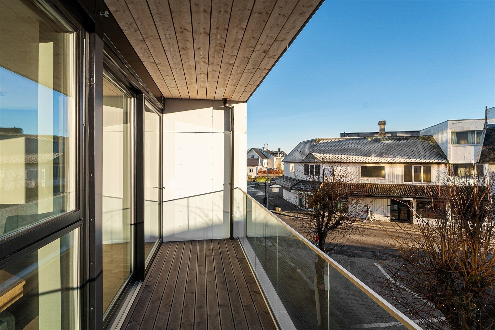 Balkongen har flott glassrekkverk og vedlikeholdsvennlige terrassebord i tre Galleribilde