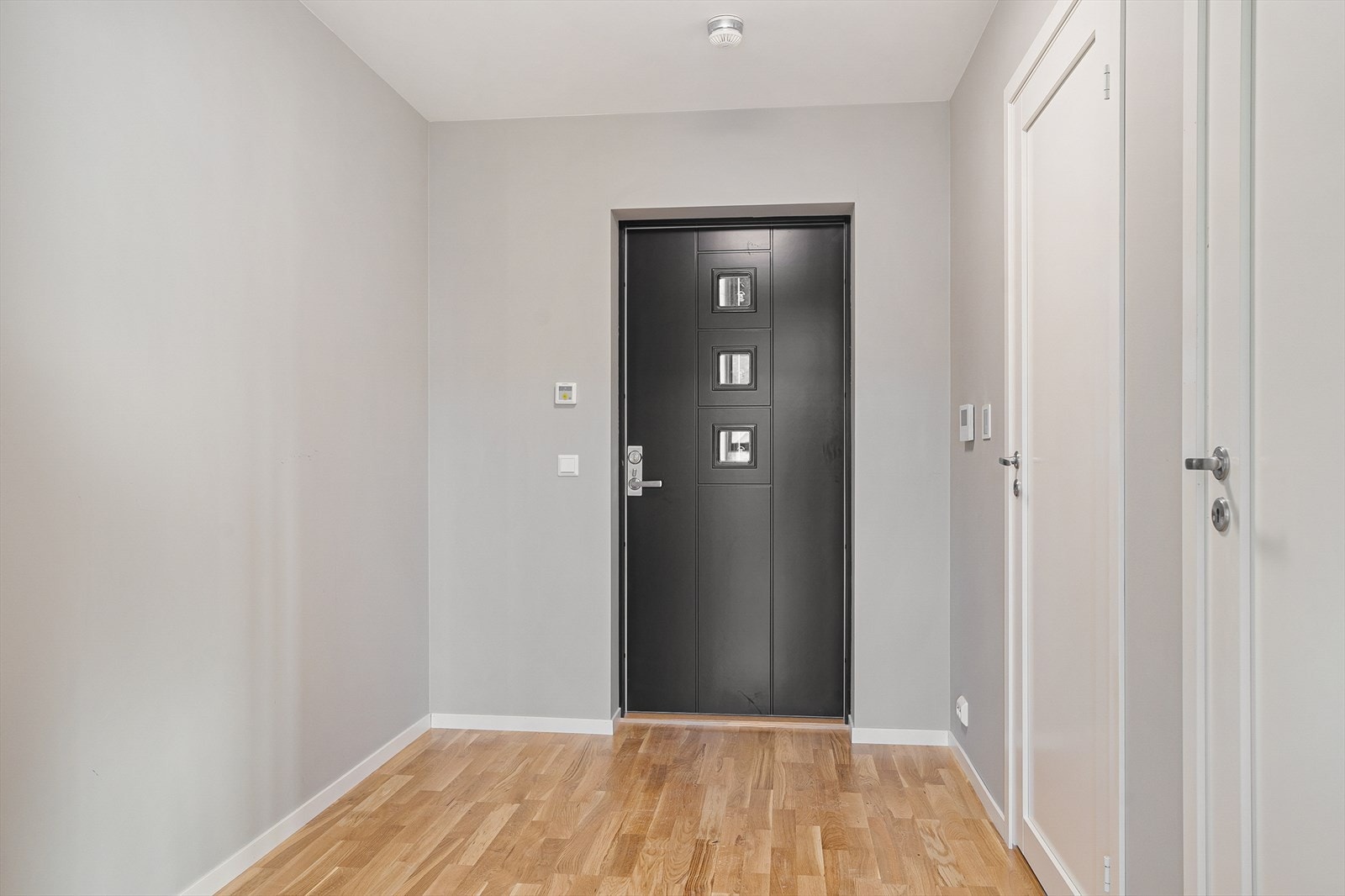 En lys og romslig gang/entré ønsker deg velkommen inn i leiligheten Galleribilde