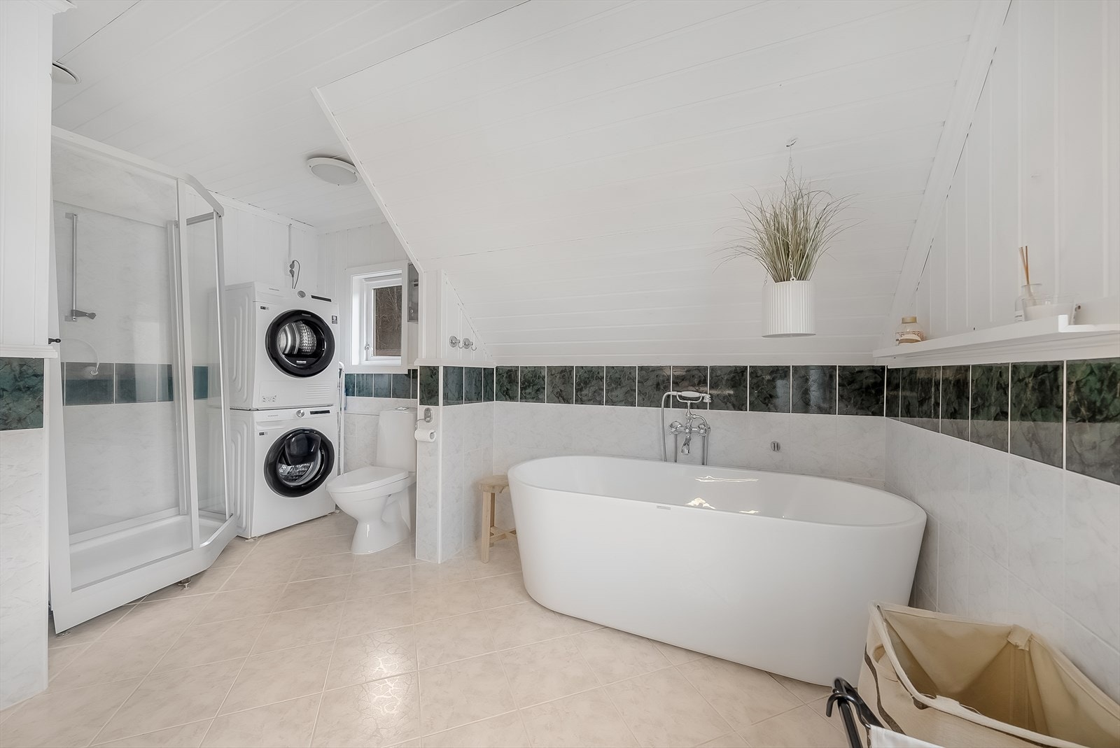 Badet ligger i 2. etasje. Rommet er innredet med baderomsinnredning toalett, dusjkabinett, badekar og opplegg til vaskemaskin. Varmekabler i gulv. Galleribilde