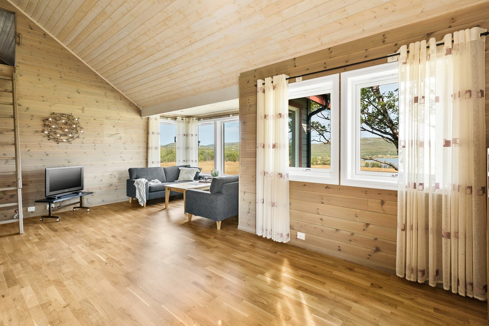 Stuen er romslig og det er god plass for flere sosiale soner. Den gode takhøyden gir rommet et luftig uttrykk Galleribilde