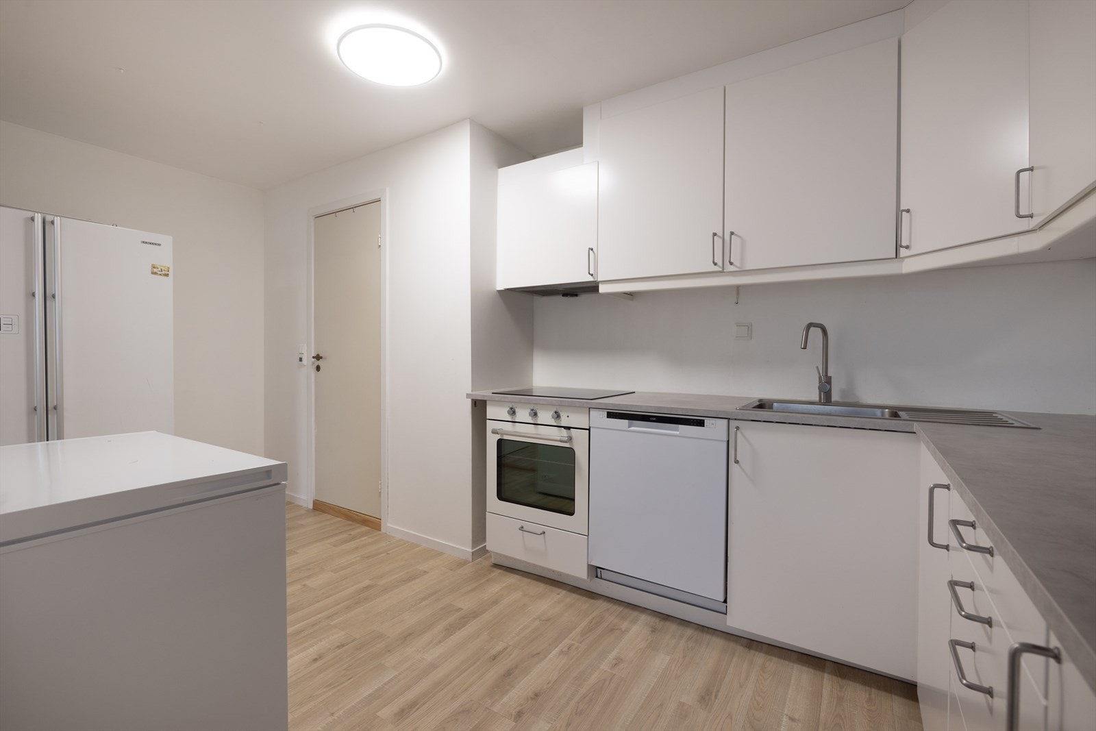 Kjøkkenet inneholder integrert komfyr og platetopp, ellers frittstående hvitevarer. Galleribilde