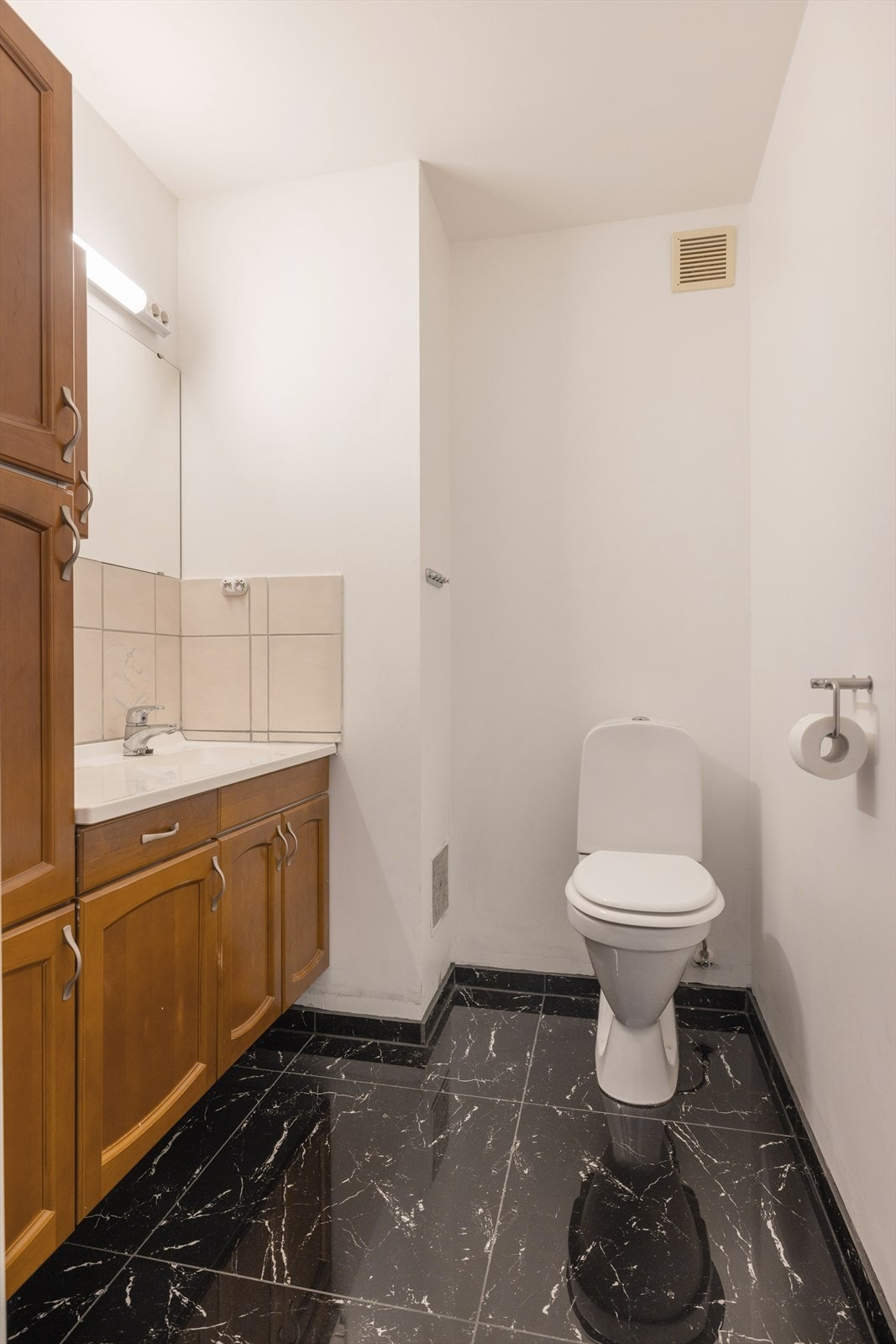 Toalettrommet inneholder servant med god skapplass og gulvmontert toalett. Galleribilde