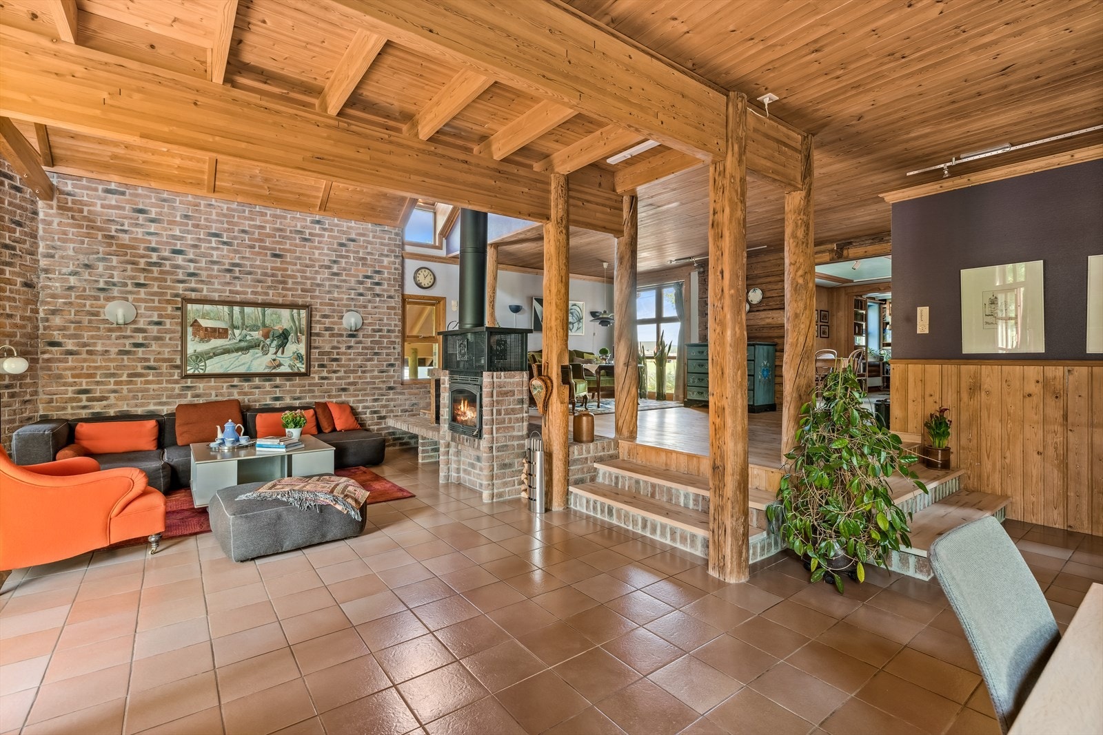 Med tre trinn ned fra salongen/spisestuen, så kommer man ned i stuen hvor man har en unik og fantastisk takhøyde samt utgang til terrasse. Galleribilde