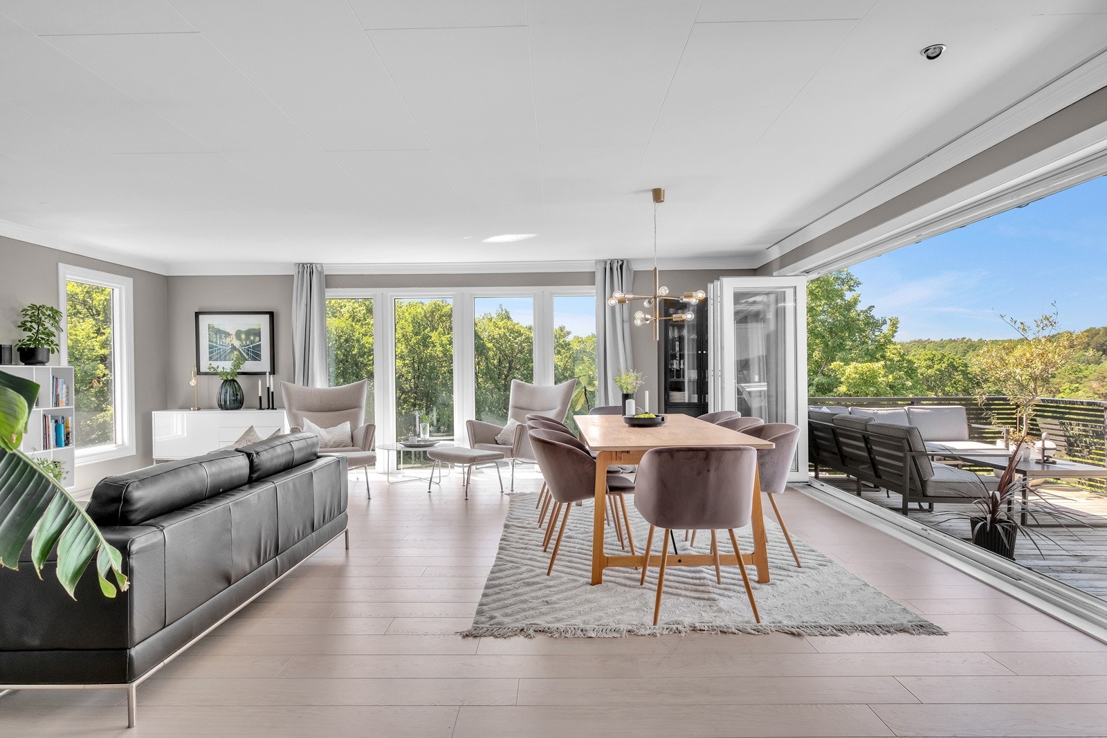 Stue med direkte utgang til solrike uteplasser - Her kan hele veggen skyves tilside slik at veggen åpnes opp. Galleribilde