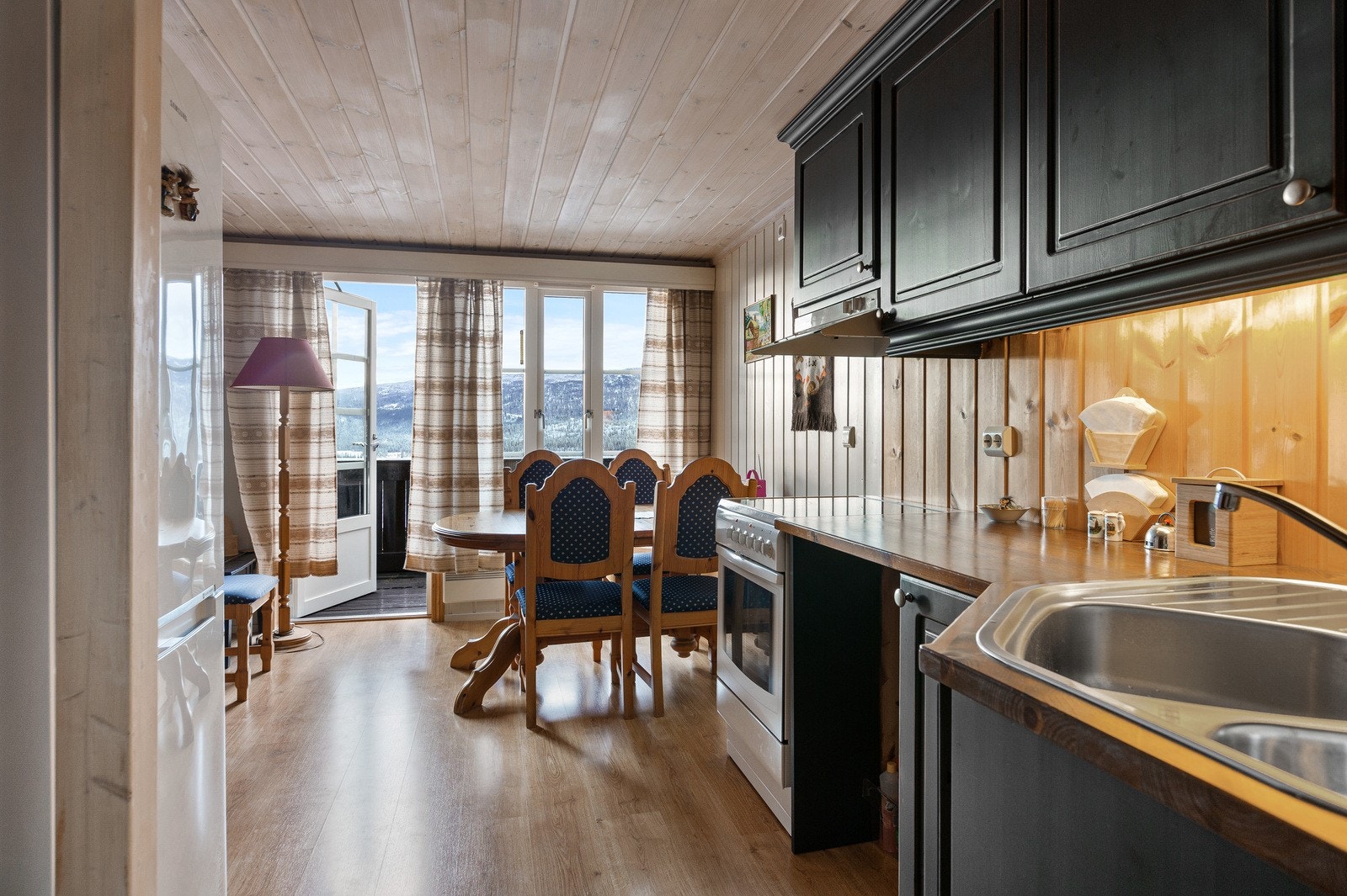 Koselig kjøkken med spiseplass og utgang til balkong. Galleribilde