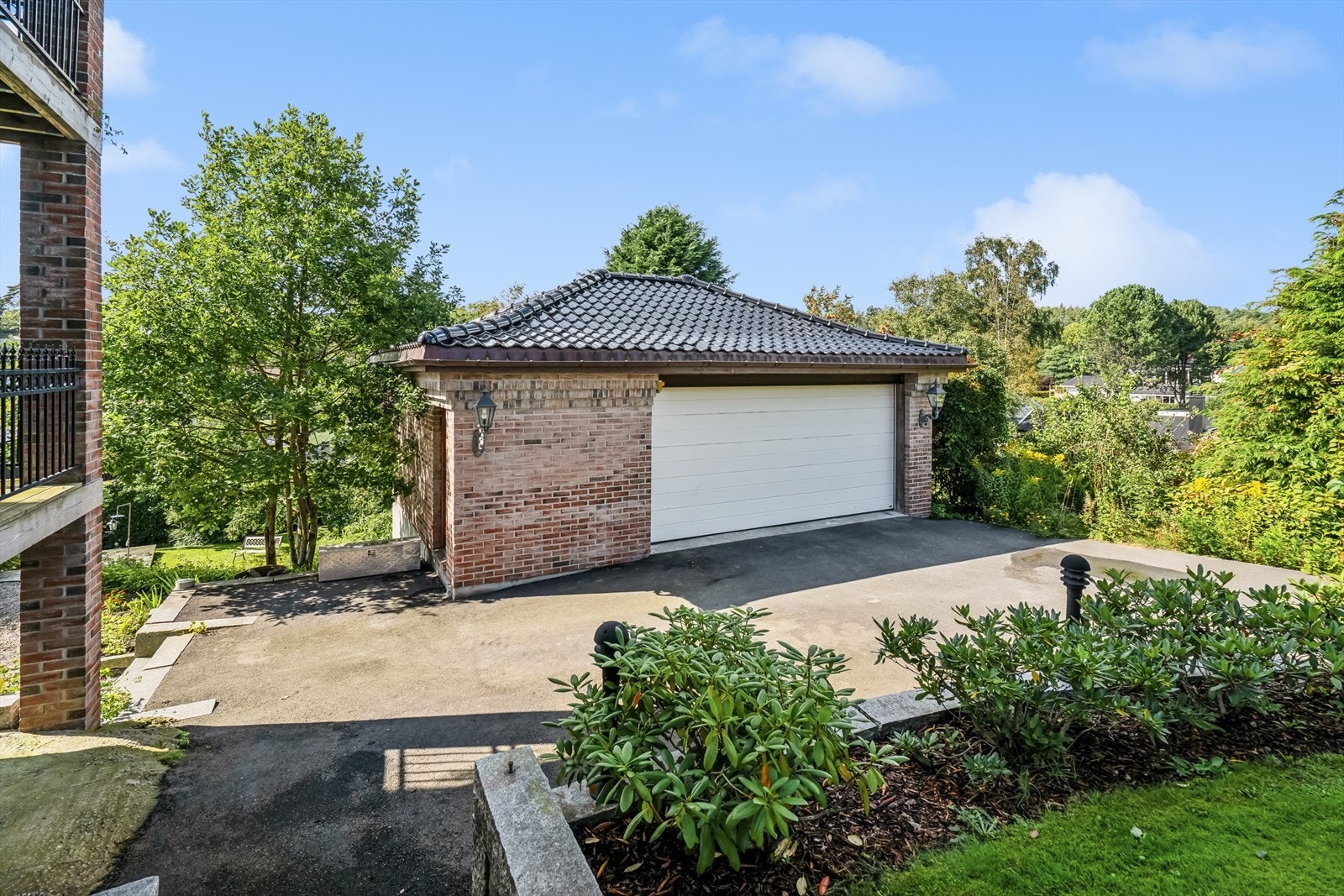 Asfaltert gårdsplass samt stor garasje med verksted i underetasjen. Galleribilde