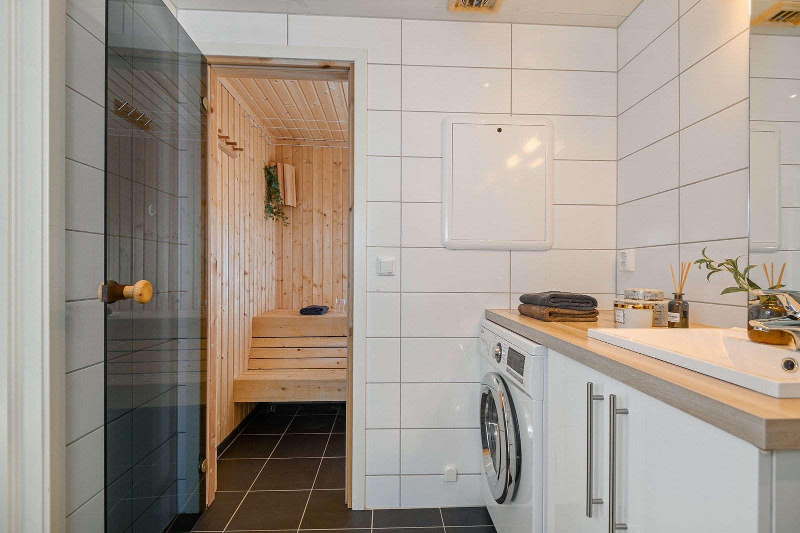 Badstue med fiser på gulv, panel på vegger og tak. Rommet er innredet med plassbygd innredning og badstueovn. Galleribilde