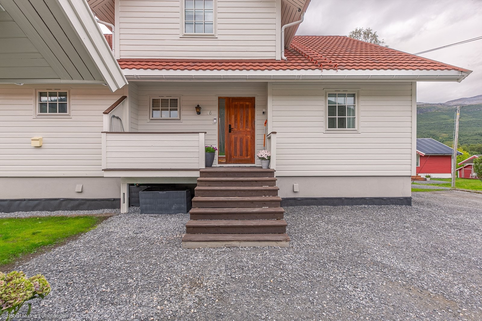 Overbygd inngangsparti delvis skjermet for vær og vind. Galleribilde