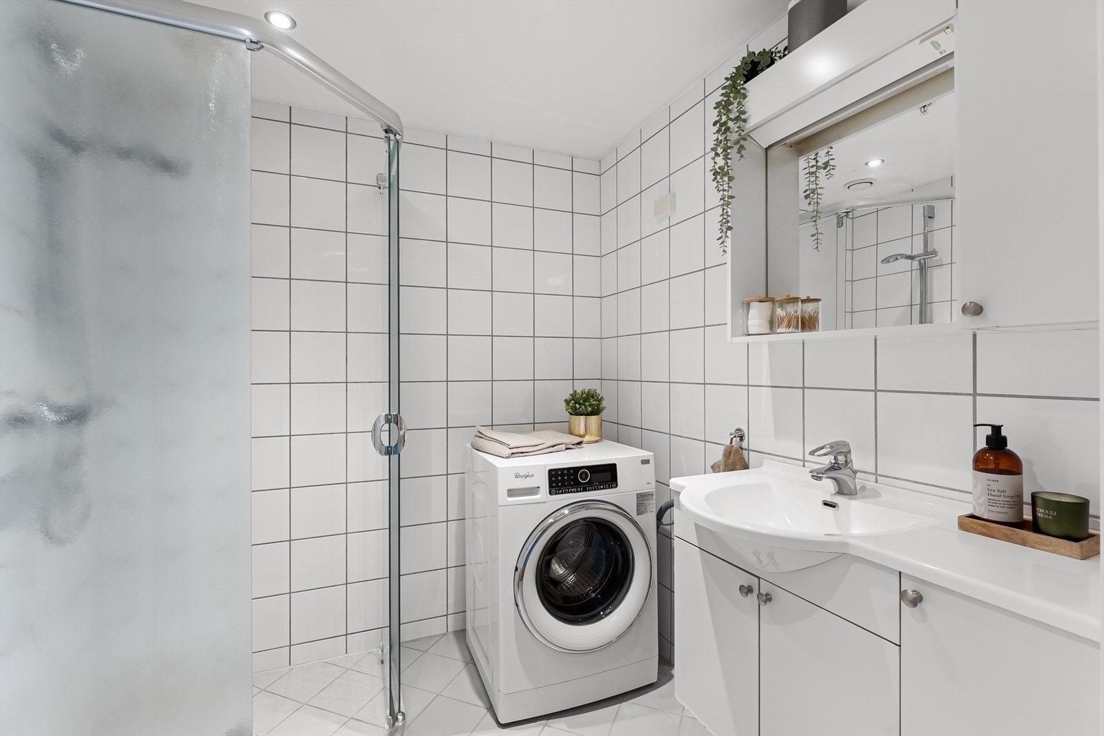 Flislagt bad med varmekabler - Dusj på gulv med dører i herdet glass og opplegg for vaskemaskin Galleribilde