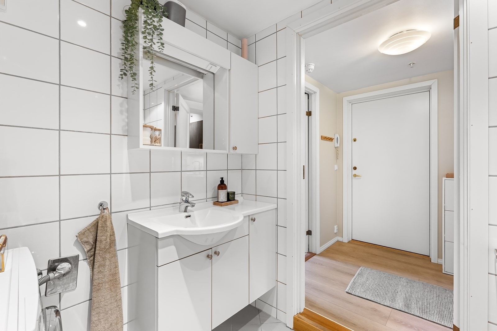 Veggfestet klosett og benkeskap med glatte fronter samt overskap med speil Galleribilde