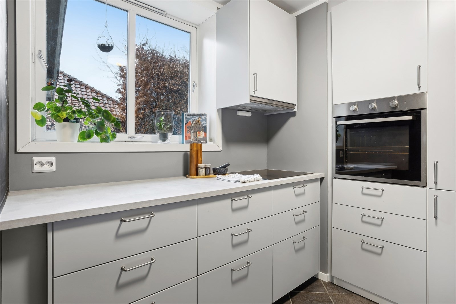 Kjøkkenet har slette fronter, laminat benkeplate, fliser på gulvet med varmekabler, og god skapplass. Galleribilde