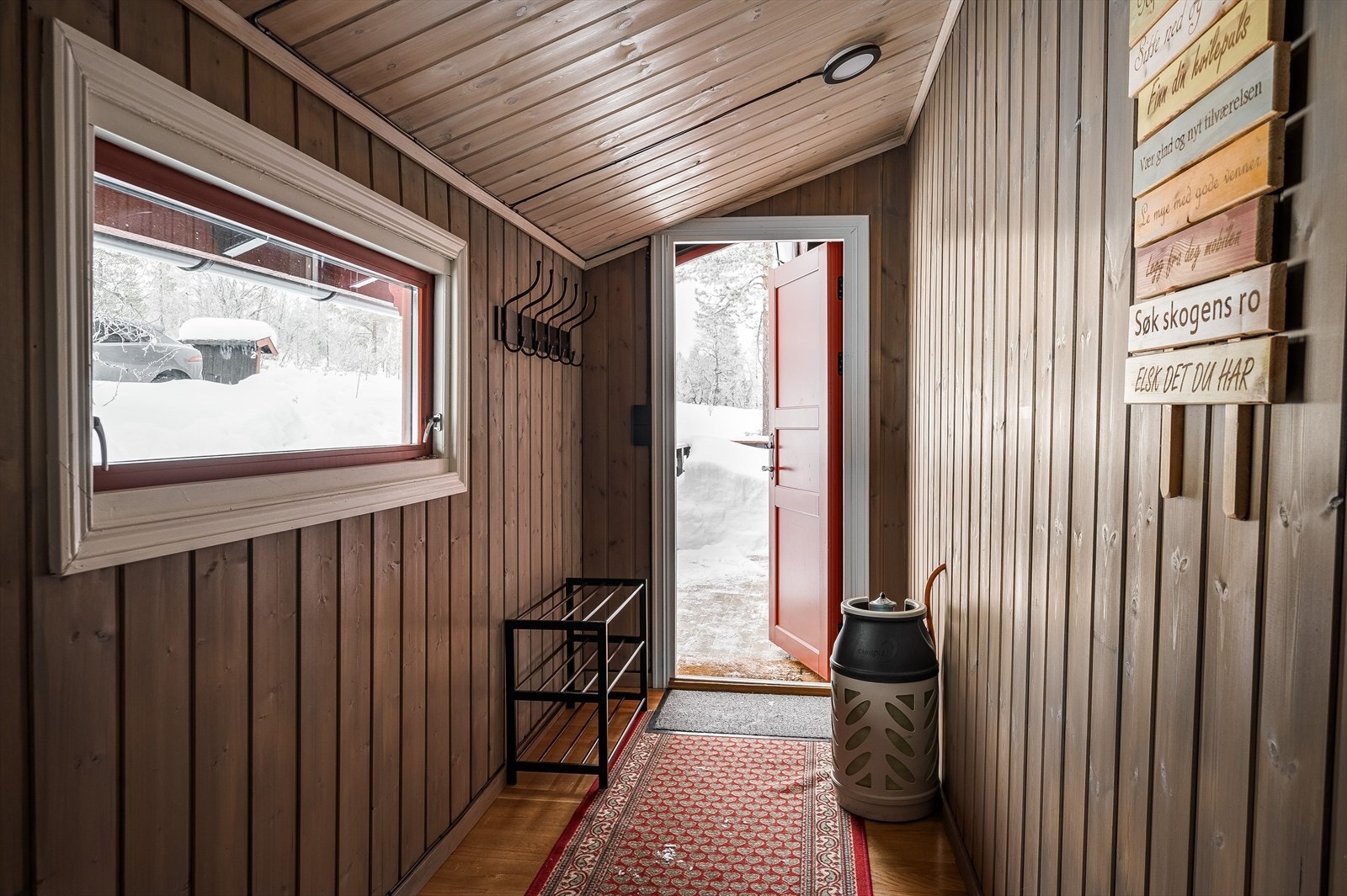 Når du entrer hytta kommer du inn i en praktisk entré med parkettgulv og beiset panelvegger. Plass til sko og oppheng av yttertøy. Galleribilde