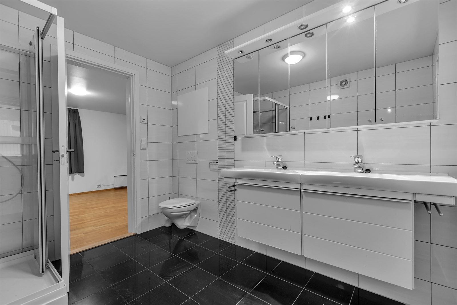 Dusjkabinett og vegghengt wc på badet. Galleribilde