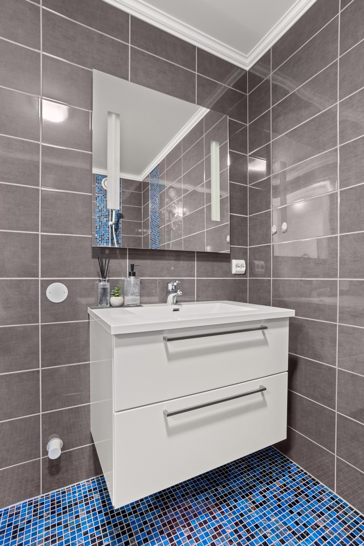 Badet er utstyrt med servantskap, WC og åpen dusj Galleribilde