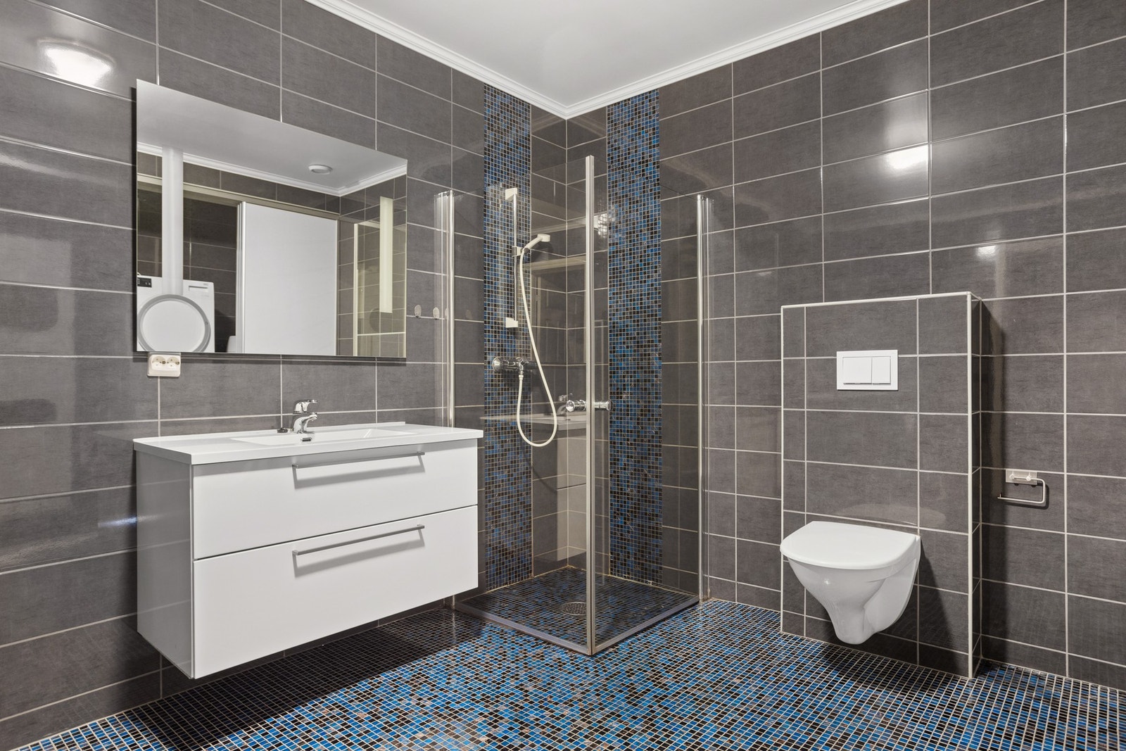 Badet er utstyrt med servantskap, WC og dusjdører Galleribilde