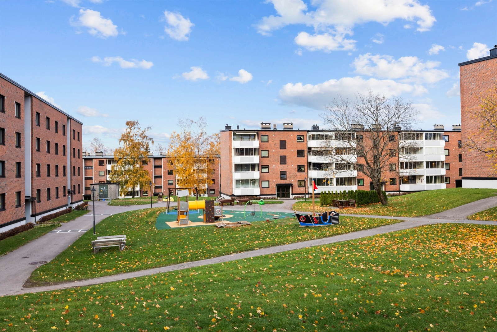 Pent opparbeidede fellesarealer med lekeplass, grøntareal og sittebenker. Galleribilde