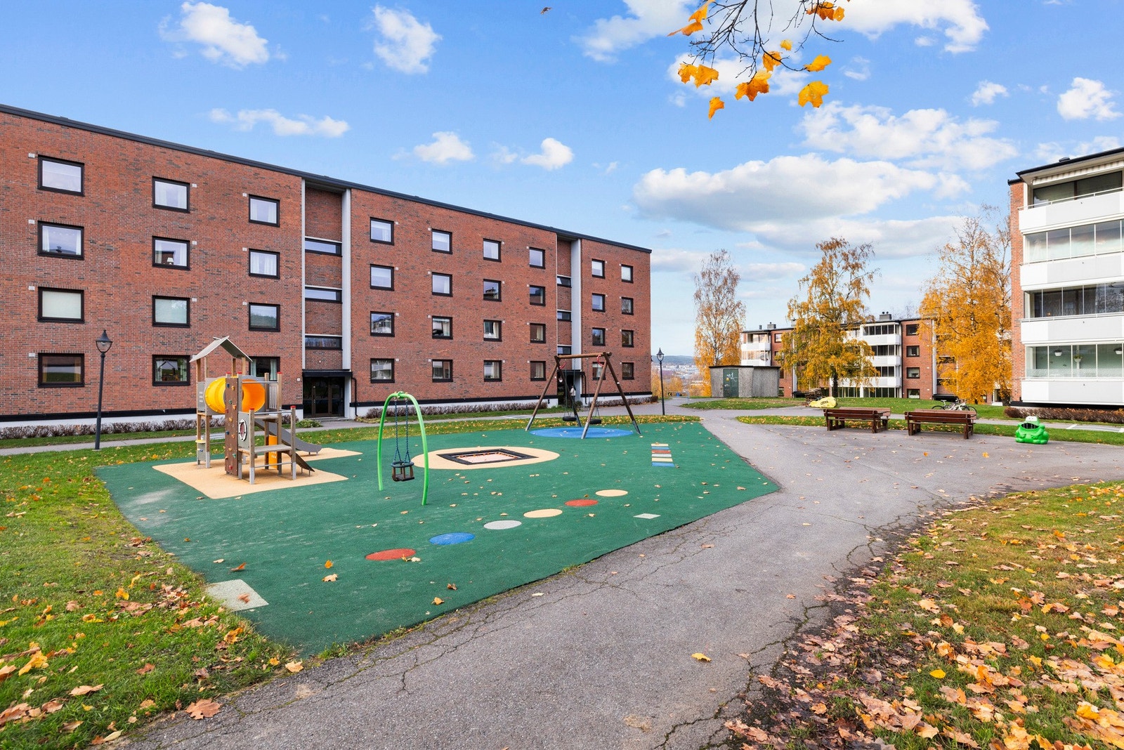 Pent opparbeidede fellesarealer med lekeplass, grøntareal og sittebenker. Galleribilde