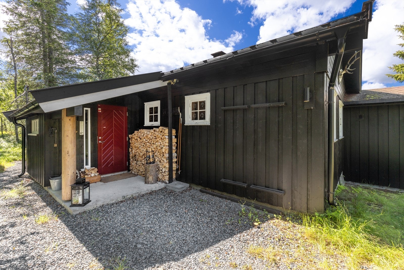 Overbygget inngangsparti med praktisk oppbevaringsplass for ved. Galleribilde