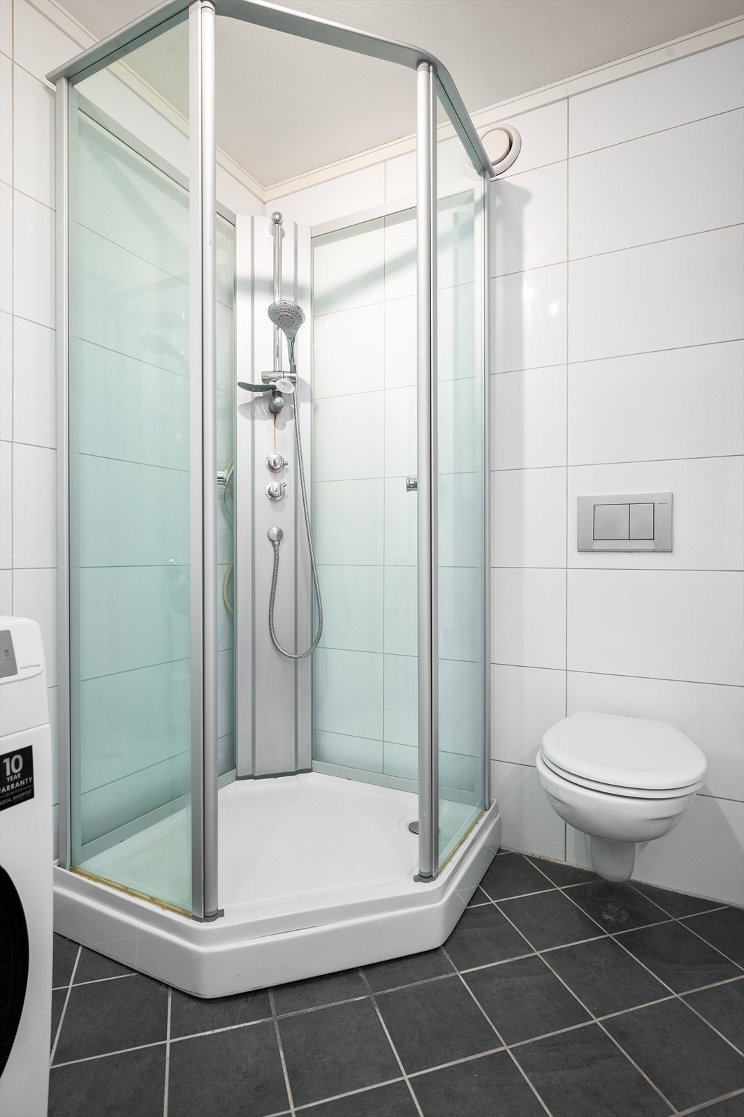 Videre har badet dusjkabinett og vegghengt klosett. Det er opplegg for vaskemaskin. Galleribilde