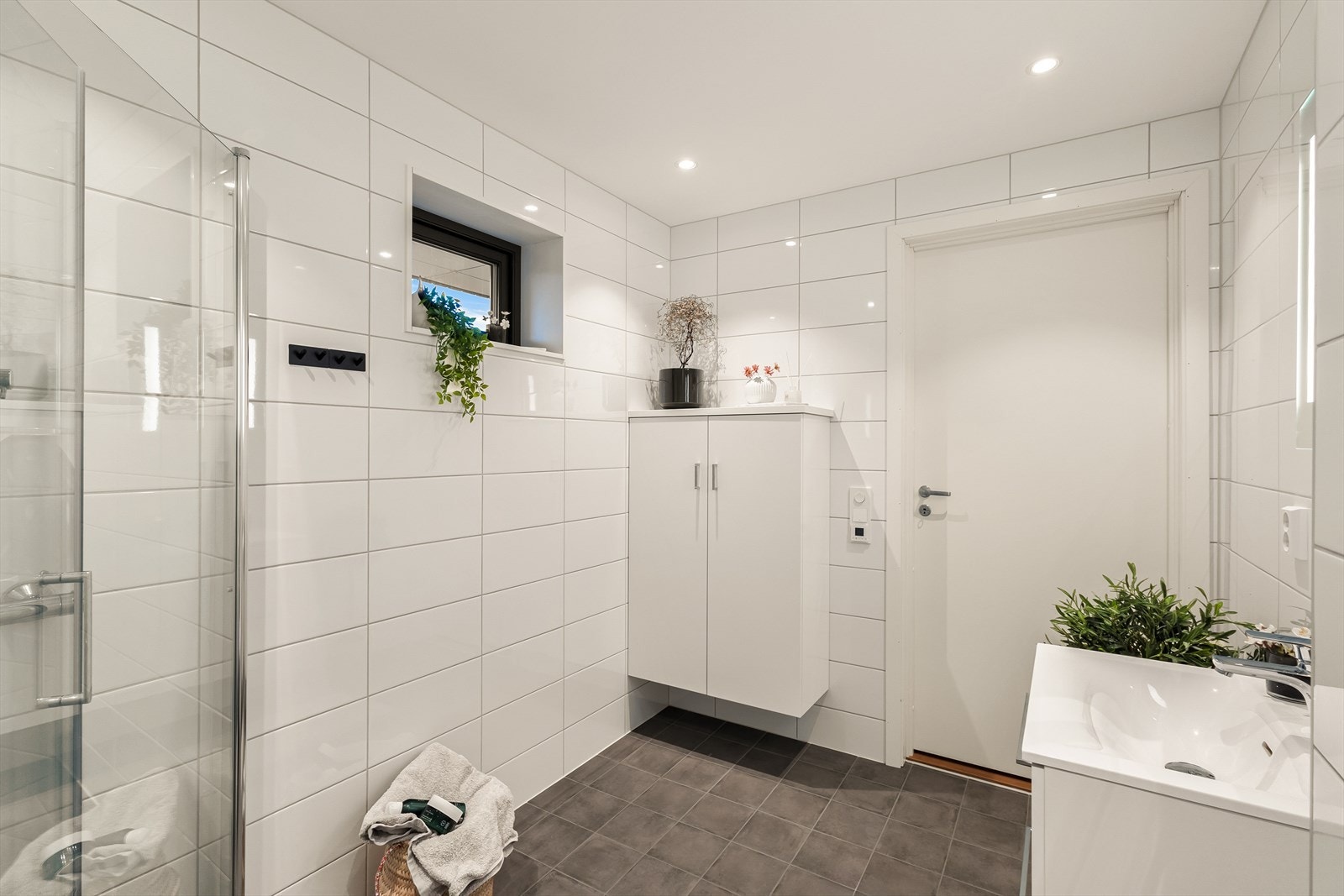 Det har downlights i himlingen og er utstyrt med vegghengt toalett, baderomsinnredning med servant, belyst speil og dusj. Galleribilde