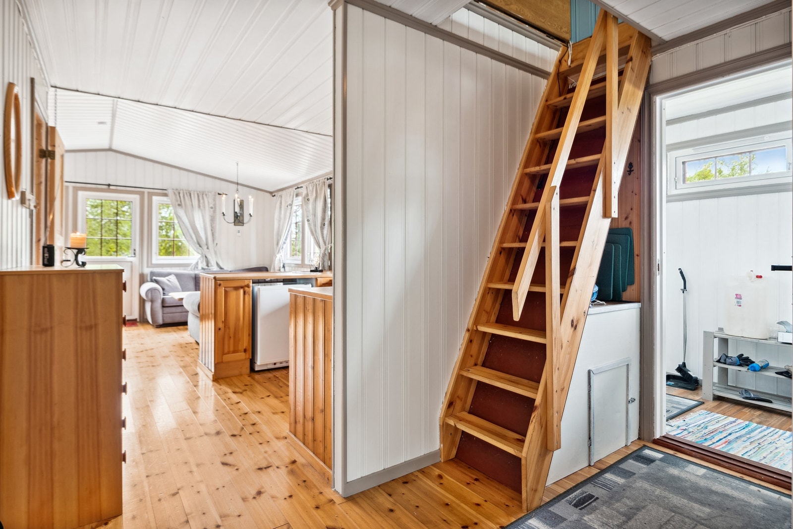 Hytta er gjennomført i stilen med stort sett malte lyse overflater på vegger og tak. Trapp opp til hemsen Galleribilde
