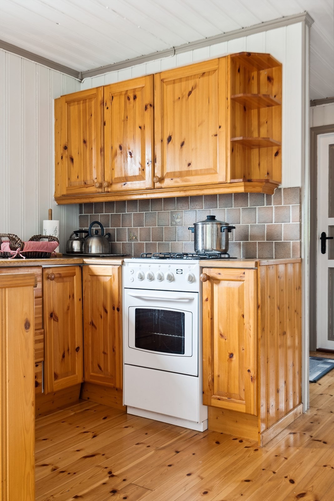 Beskyttende fliser over kokesone. Kjøleskap, komfyr og kokeplater på gass. Galleribilde