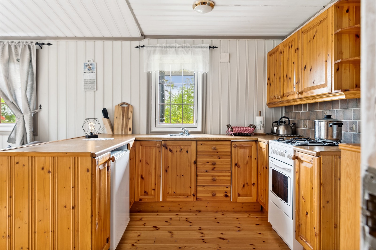 Kjøkkenkrok med profilerte fronter og åpen løsning for hvitevarer. Galleribilde