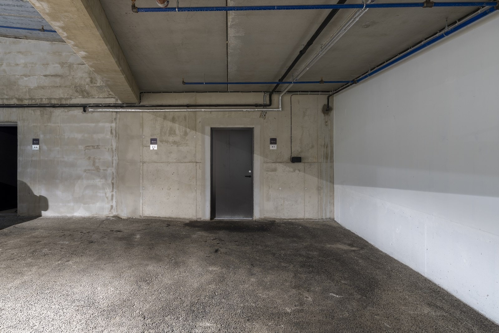 Parkeringsplass med elbillader og inngang til en av bodene med direkte adkomst til skibakken Galleribilde