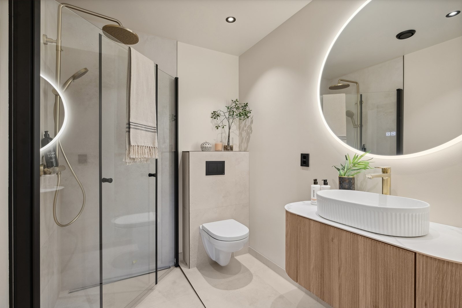 Badet er innredet med vegghengt wc, dusj med glassdører, baderomsinnredning med bollevask, samt speil med belysning Galleribilde