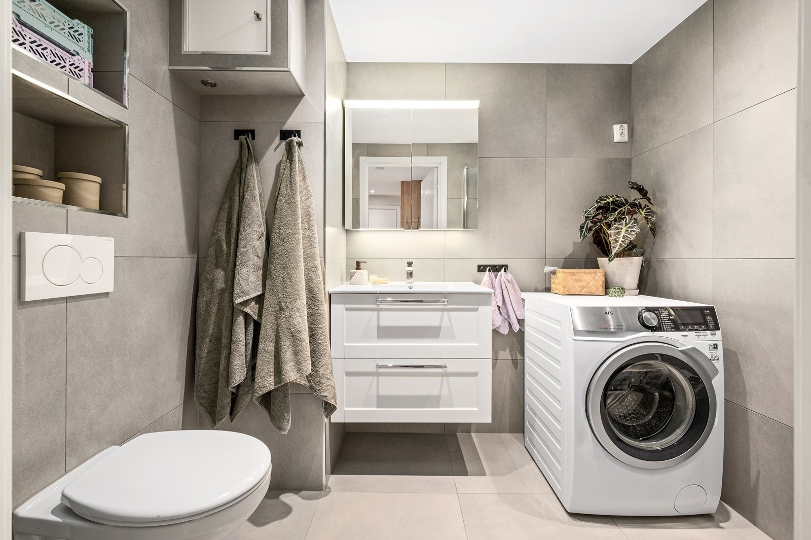 Delikat og flislagt baderom med varmekabler i gulv og downlights i himling. Opplegg og plass til vaskemaskin og tørketrommel. Galleribilde