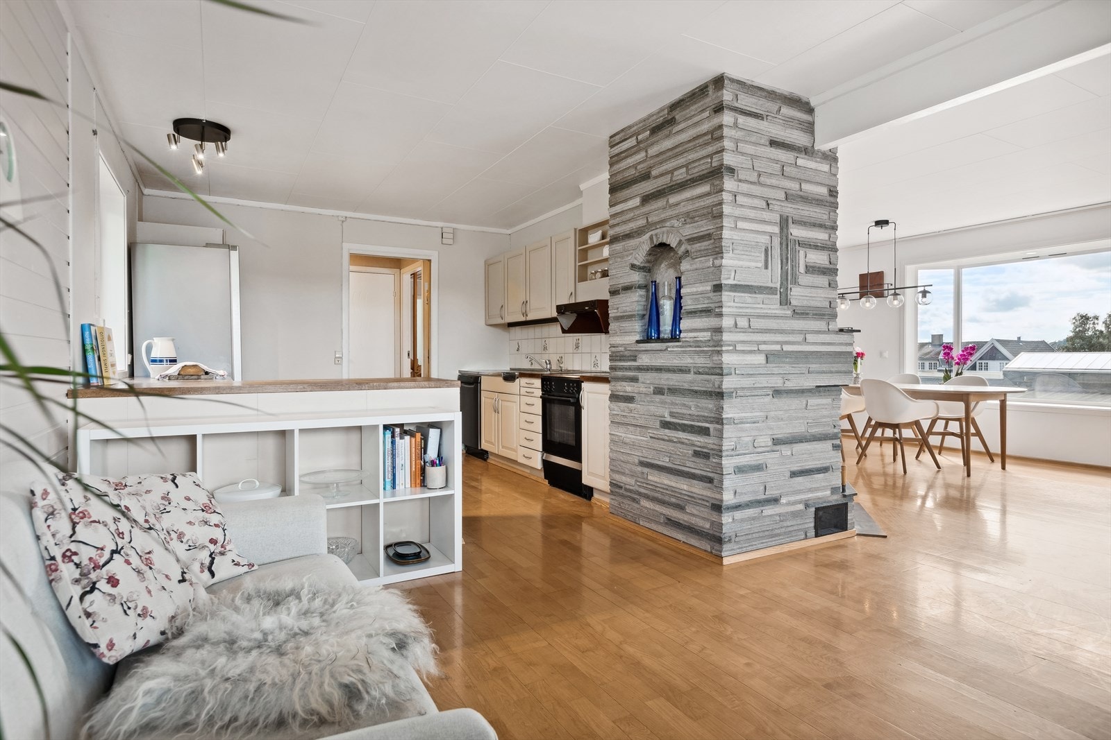 Lys kjøkkeninnredning med profilerte fronter, benkeplater av eik, ventilator over kokesonen og dobbel oppvaskkum med ett-greps blandebatteri. Galleribilde