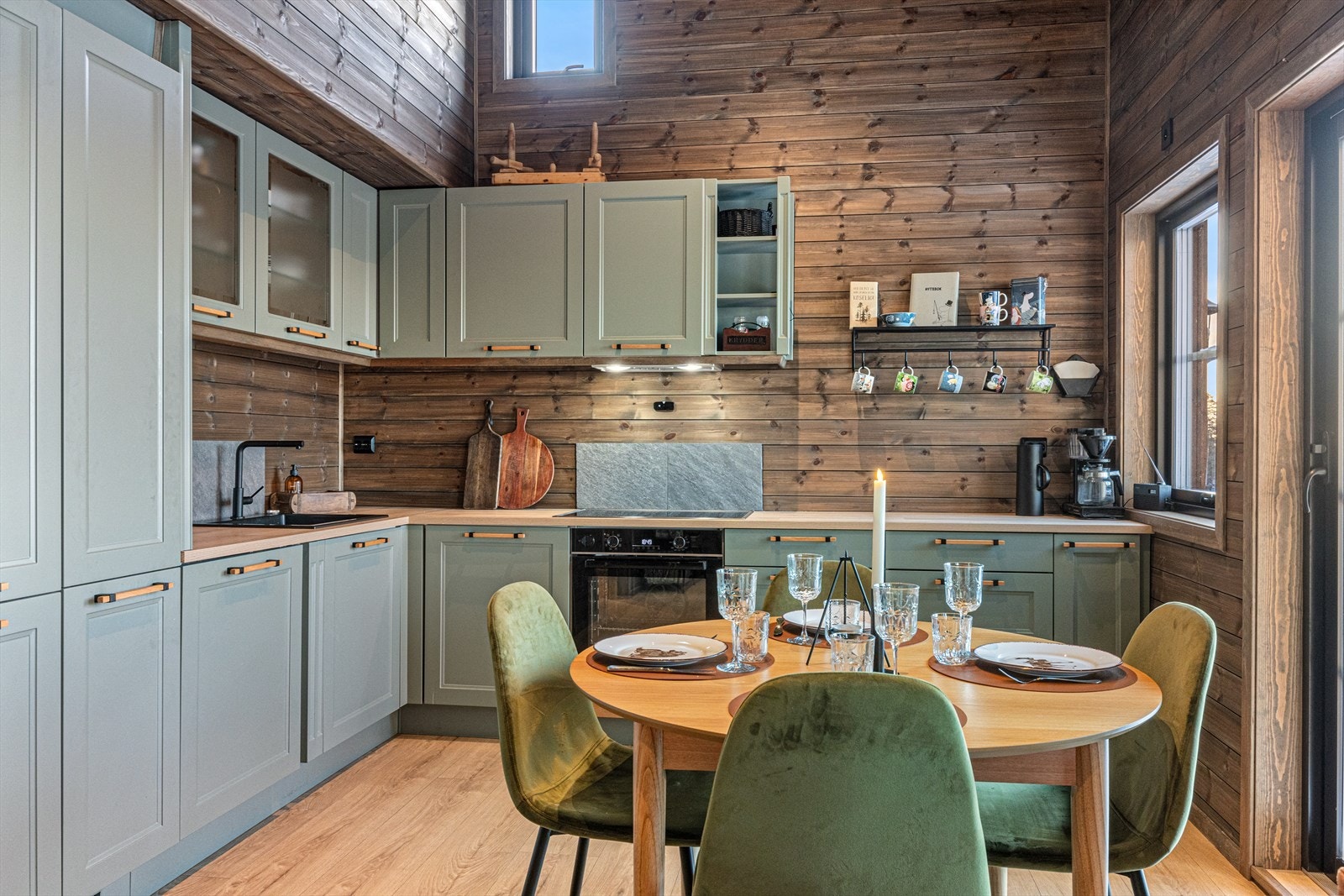 Moderne kjøkkeninnredning med profilerte fronter og laminerte skrog. 2 overskap med glassfronter. Benkeplater av laminat med nedsenket oppvaskkum med kompositt. Galleribilde