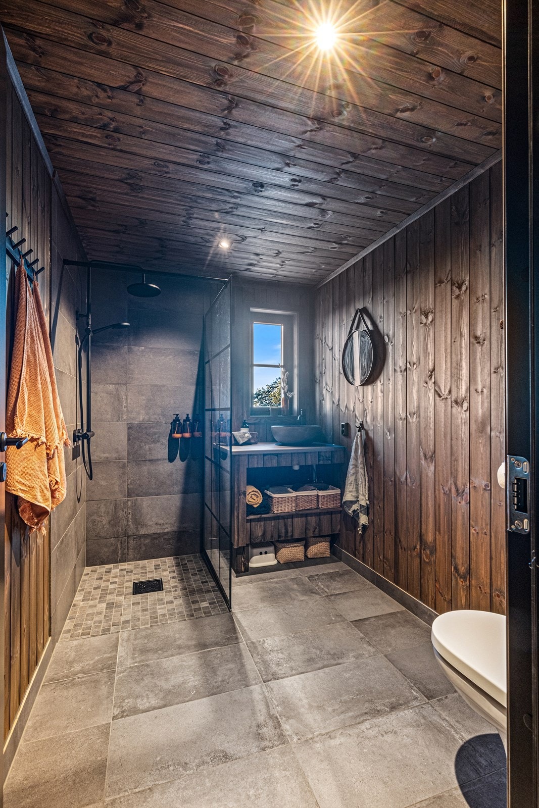 Badet har flis på gulv med termostatstyrt varme, vegger med sokkelfliser, behandlet panel på vegg og i himling med dimbare downlights. Galleribilde