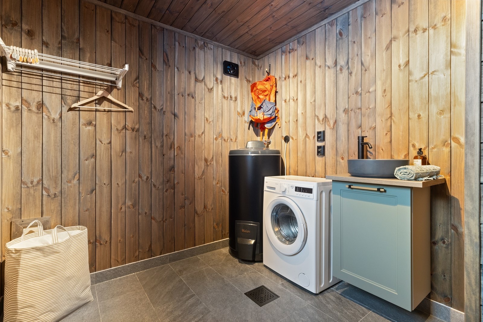 Toalett-/vaskerom har servant på innredning og plassering av bereder. Opplegg for vaskemaskin og tørketrommel. Det er flis på gulv med termostatstyrt varme, vegger med sokkelflis og behandlet panel. Behandlet panel i himling med spotlights. Galleribilde