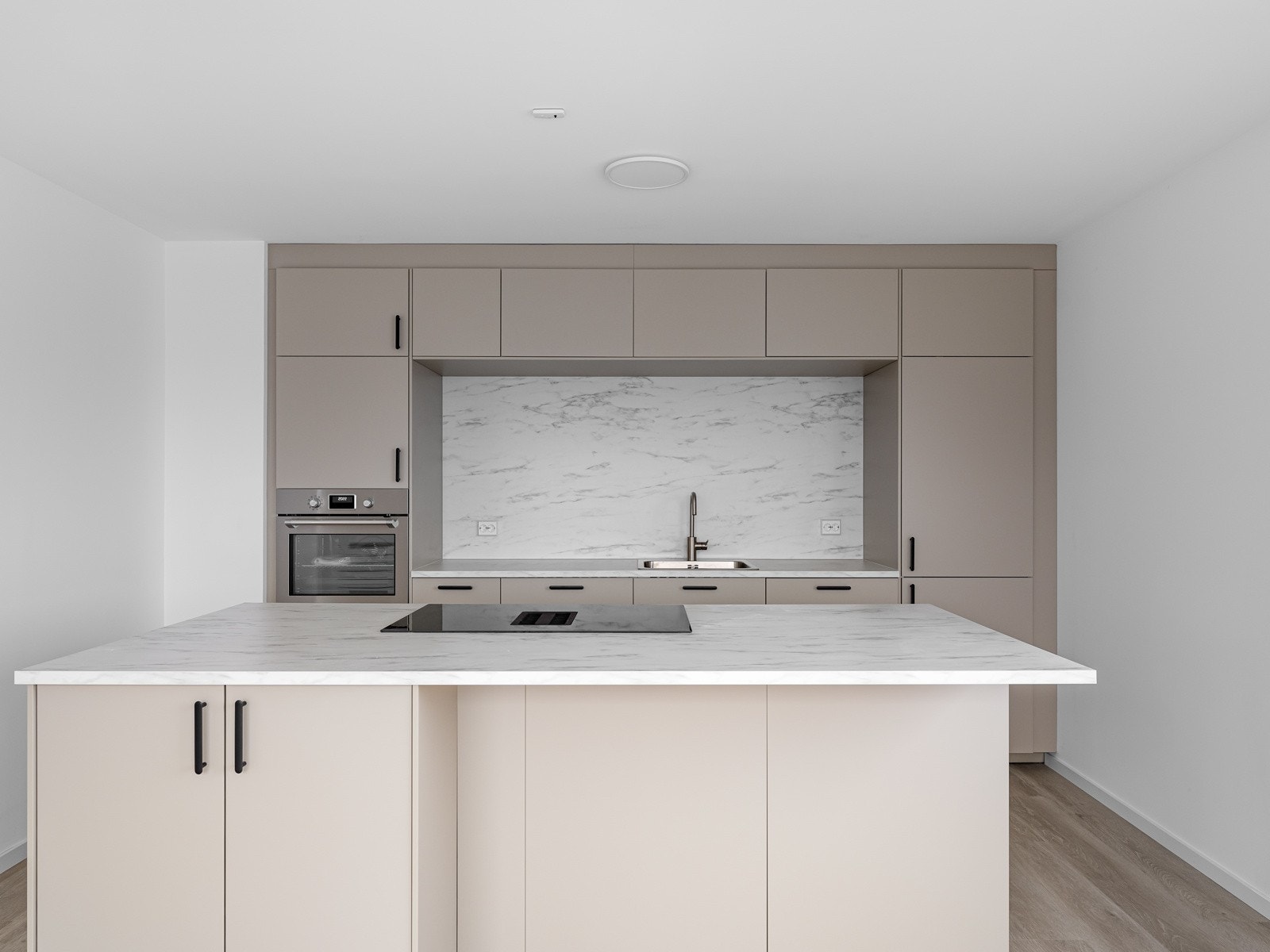 Lekkert kjøkken med øy med spiseplass, lagring og platetopp Galleribilde