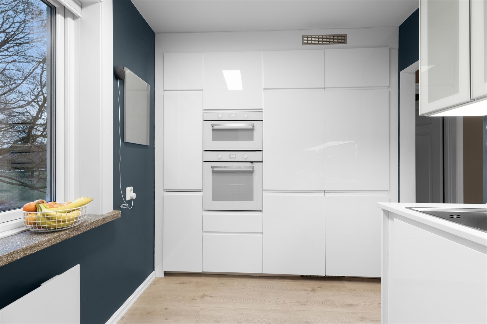 Kjøkkenet har høyglans fronter og takhøye skap Galleribilde