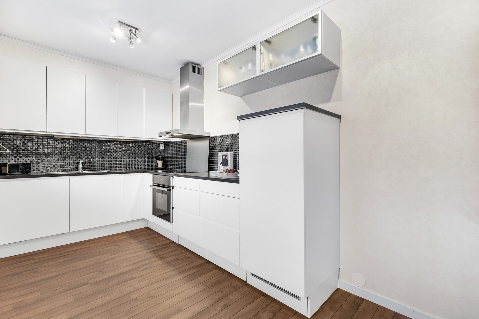 Pent, tidløst kjøkken fra 2009 med integrerte hvitevarer. Galleribilde