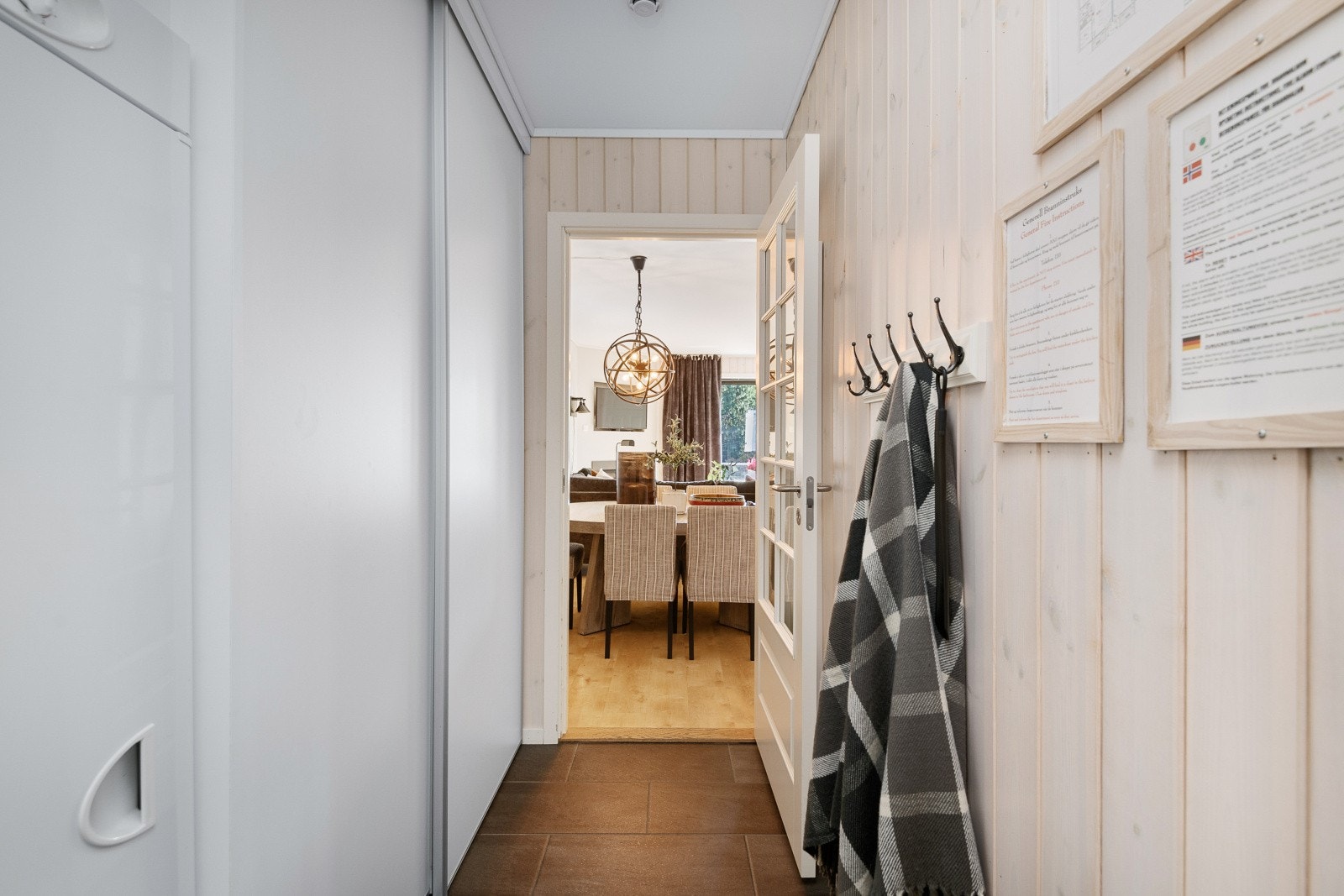 Lys entré med flislagt gulv. Det er god plass til å henge fra seg yttertøy i en romslig skyvedørsgarderobe. Tørkeskap til venstre i bildet. Galleribilde