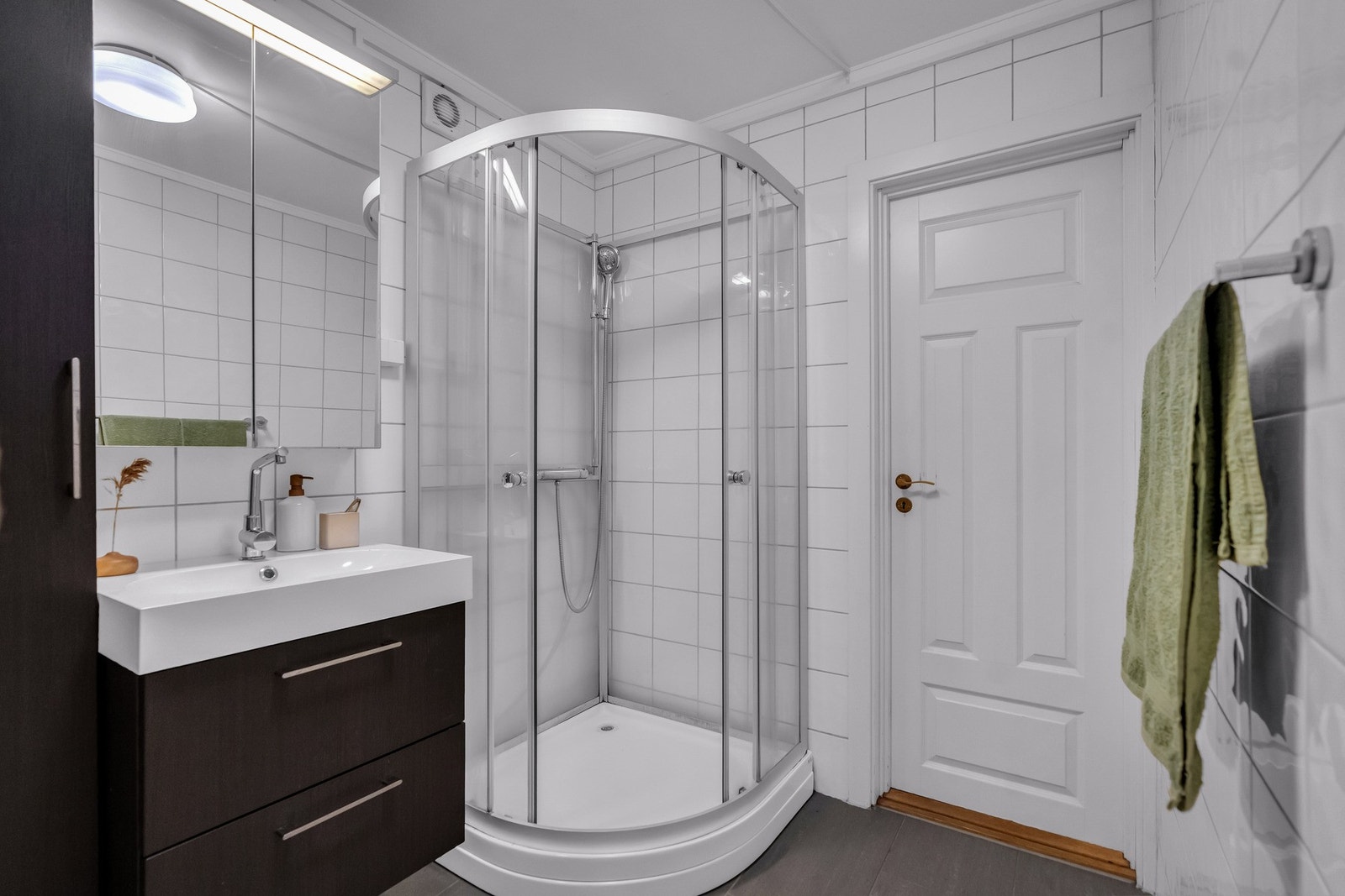 Badet inneholder vegghengt servant, toalett og dusjkabinett Galleribilde