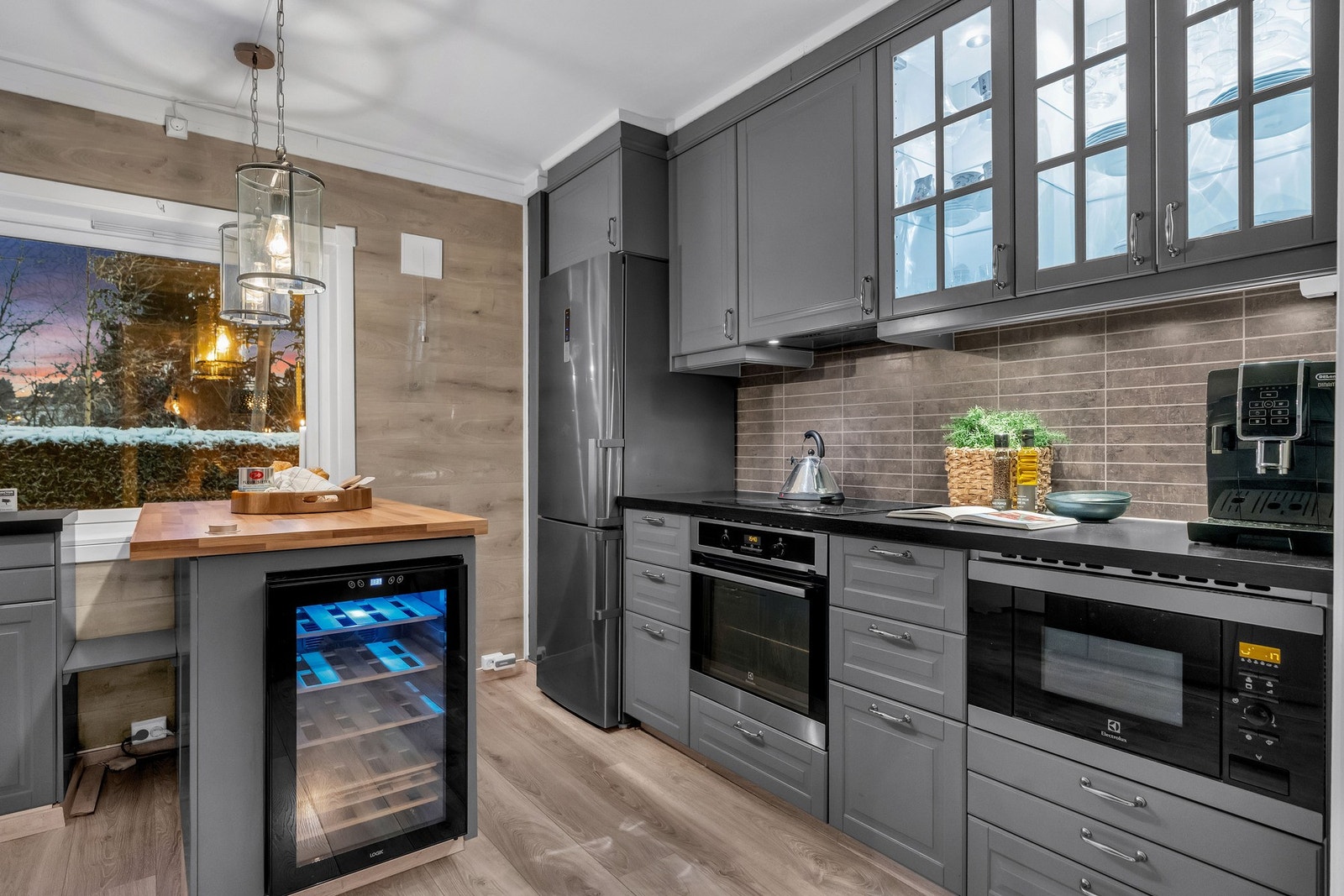 Mørk benkeplate og grå, profilerte kjøkkenfronter gir et moderne uttrykk. Galleribilde