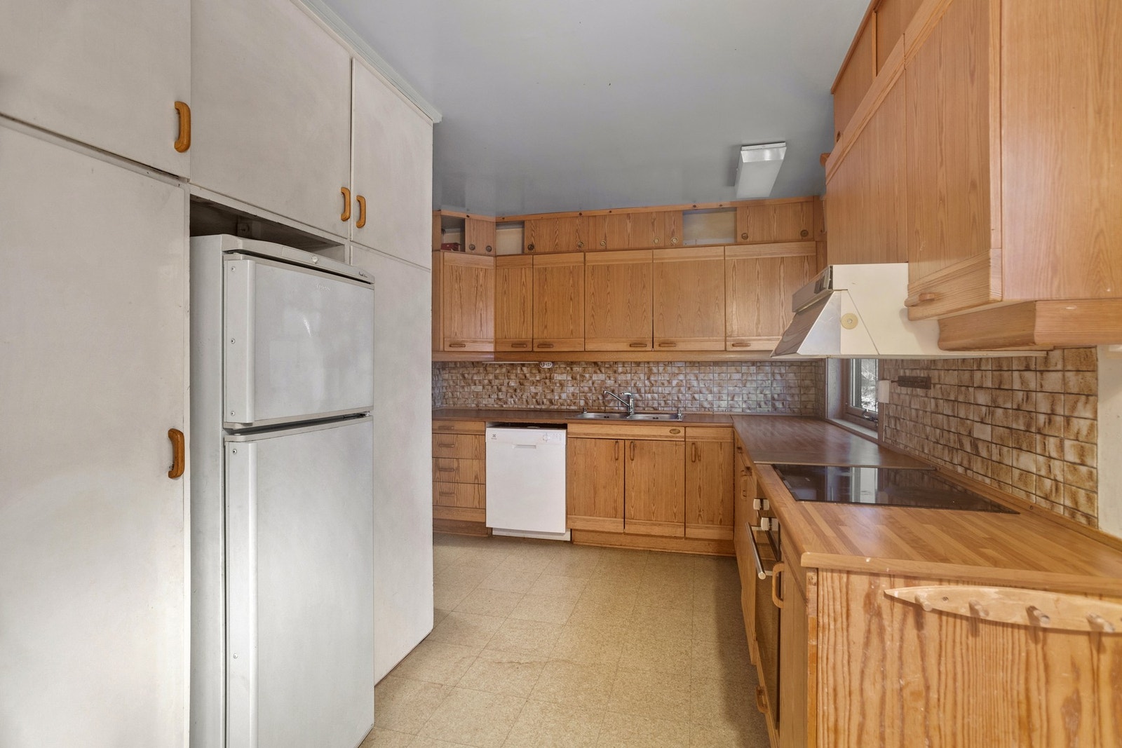 Kjøkken - ca 13 kvm. Eldre innredning med avsatt plass for hvitevarer, samt integrert platetopp og stekeovn Galleribilde