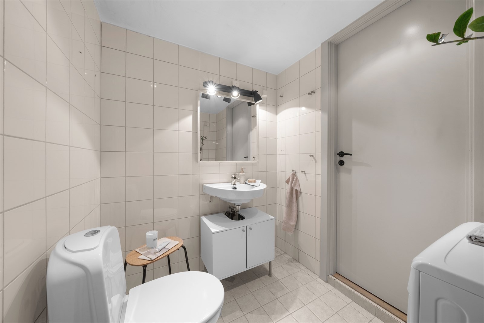 Innredning bestående av frittstående klosett, servant med ettgreps blandebatteri, dusjdører, dusjarmatur, opplegg og plass til vaskemaskin. Galleribilde