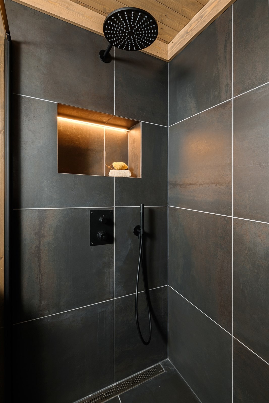 Badet er videre utstyrt med speil m/LED lys, dobbelvask, vegghengt toalett, dusjhjørne og avtrekkvifte i vegg. Galleribilde