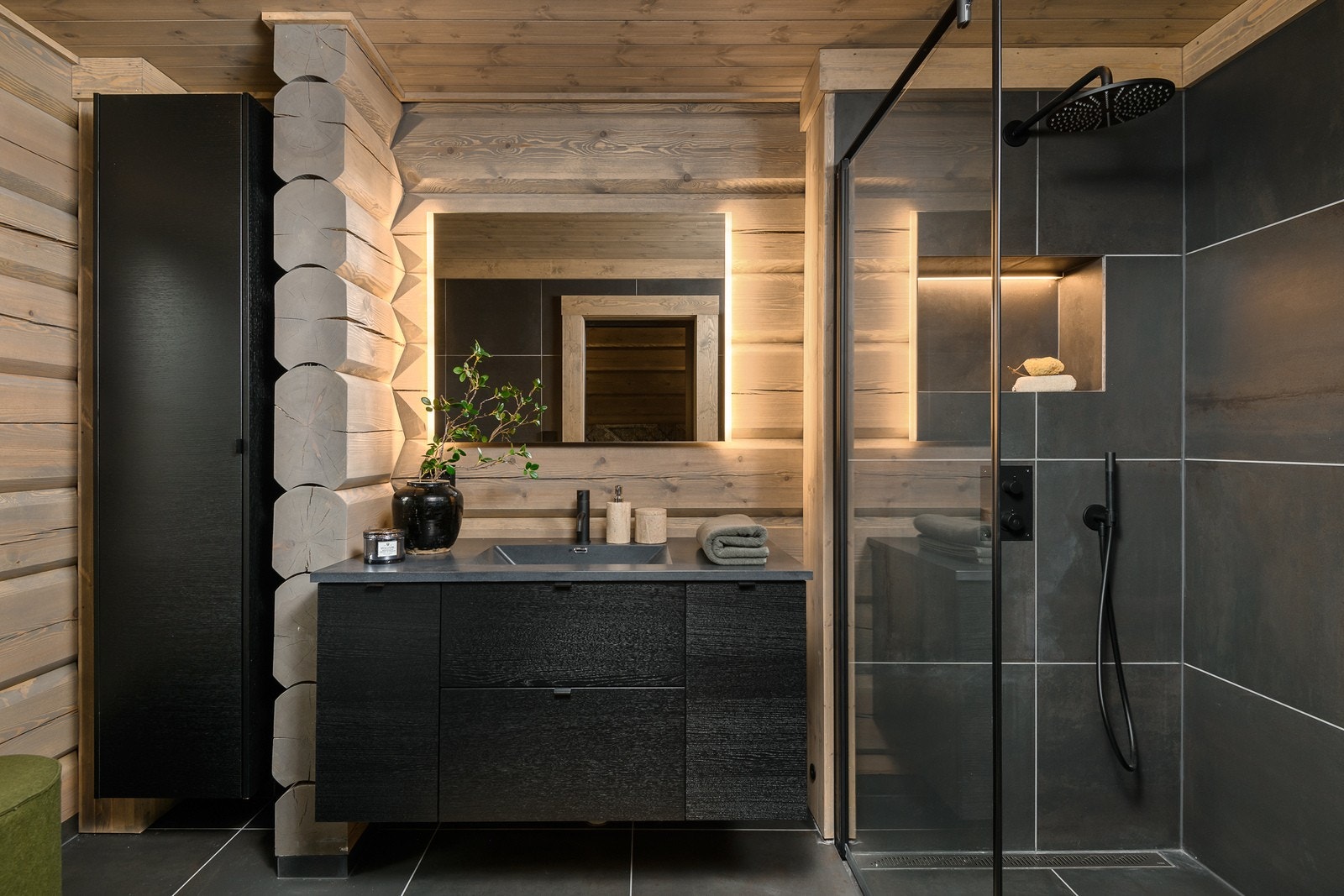 Badet innenfor hovedsoverommet har vannbåren varme, flislagt gulv, tømmervegger og downlights med panel i himling. Galleribilde