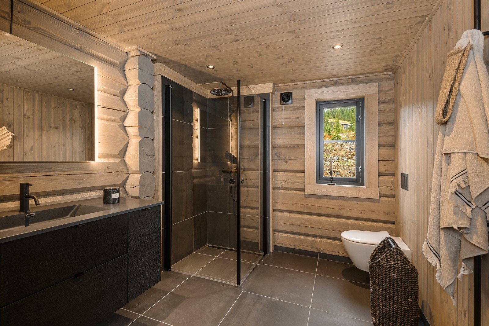 Fra entréen er det adkomst til hovedbadet, også med vannbåren varme i flislagt gulv, tømmervegger og panel med downlights i himling. Galleribilde