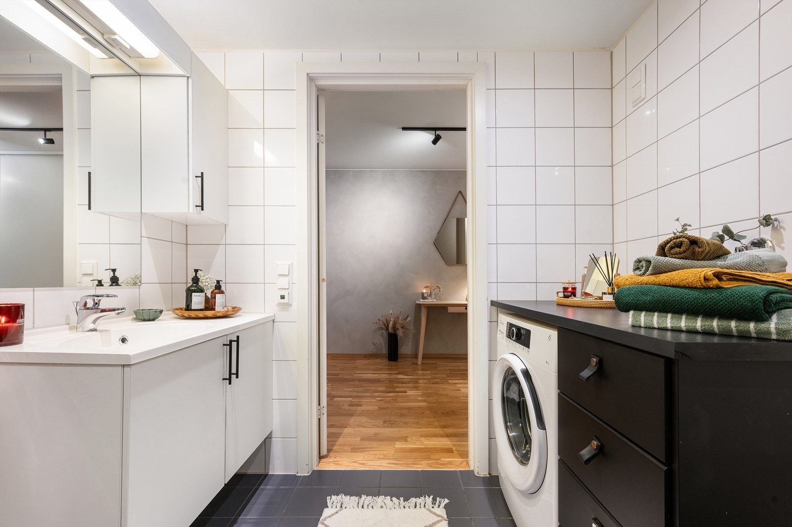 Badet er utstyrt med en heldekkende servant på underskap, speil med belysning, vegghengt toalett og dusj med herdet glassvegger. Det er også opplegg for vaskemaskin. Galleribilde