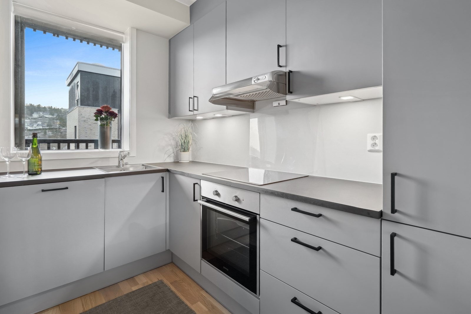 Lys kjøkkeninnredning med glatte fronter, rikelig med skap- og benkeplass. Galleribilde