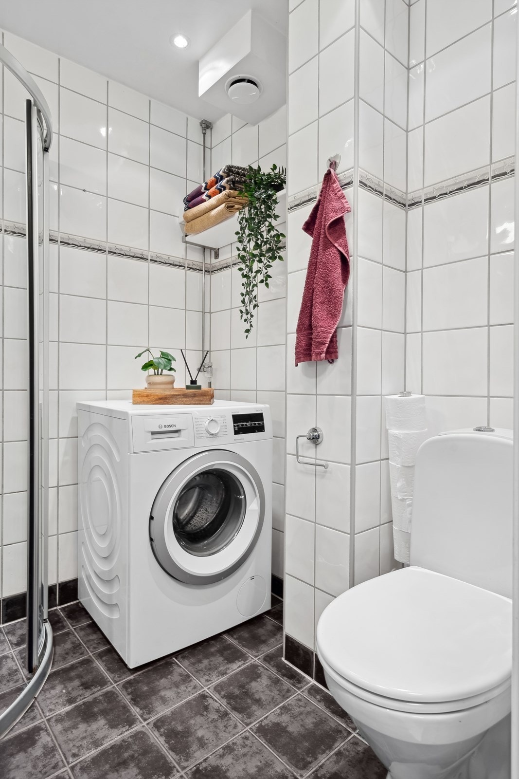 Her er det et praktisk dusjhjørne og opplegg for vaskemaskin, samt varmekabler i gulvet. Galleribilde