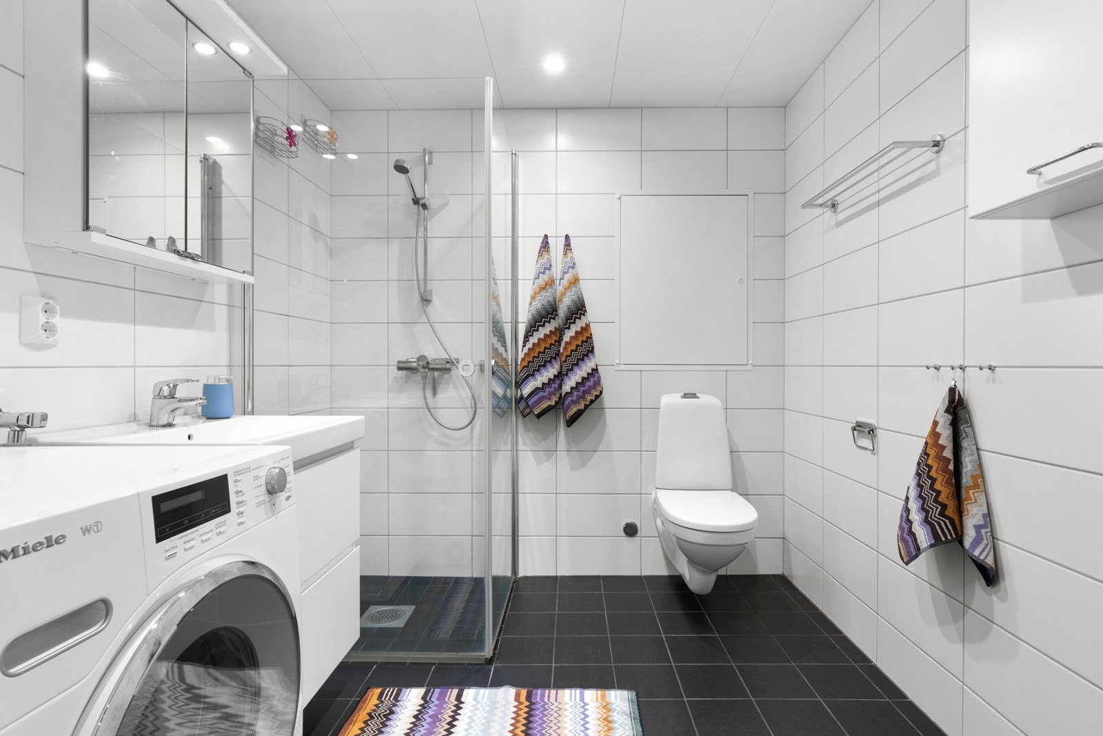 Videre er badet utstyrt med toalett og dusjhjørne Galleribilde