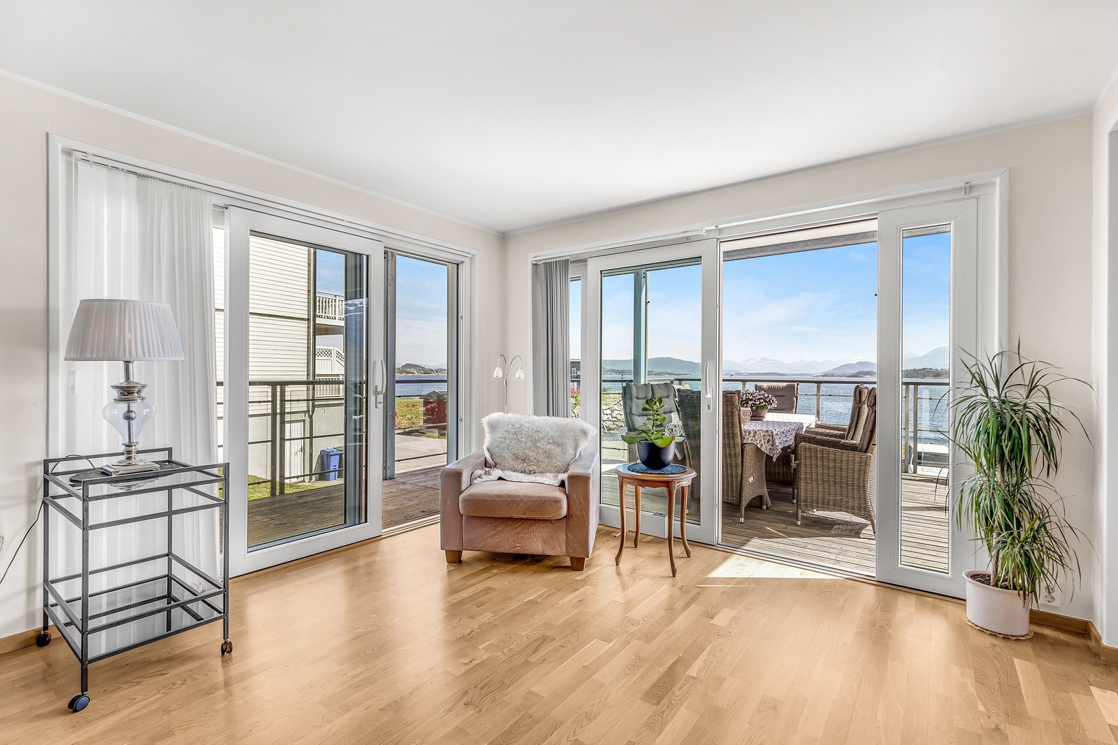 Lys og luftig stue med store vinduer, som gir fantastisk utsikt mot sjøen og fjellene. Perfekt for avslapning. Galleribilde